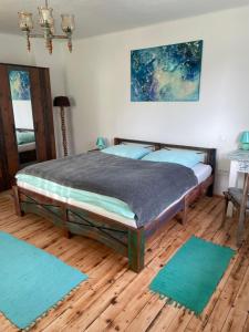 a bedroom with a bed with blue rugs on the floor at Chata Studnička Šumiac in Šumiac