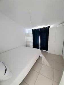 a bedroom with a white bed and black curtains at Apartments House of Art in Nin