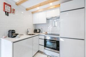 a kitchen with white cabinets and a refrigerator at GuestReady - The New Pateo da Lapa - Casa 3 in Porto