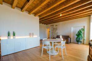 una cucina e una sala da pranzo con tavolo e sedie di FEEL - Pareto Apartment a Bergamo