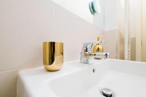 un lavandino con rubinetto e specchio di FEEL - Pareto Apartment a Bergamo