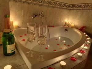 une baignoire avec deux verres à vin et des bougies dans l'établissement Evris House 1, à Kavala 52 autres photos