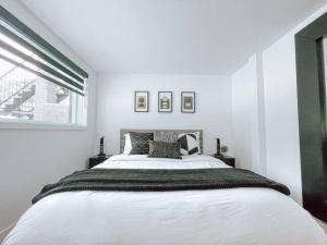 um quarto com uma grande cama branca e uma janela em Complexe LIVTremblant by Gestion ELITE - LIV5 em Mont-Tremblant