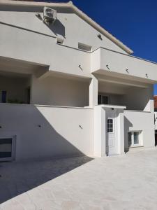 a white house with a white wall at Apartments House of Art in Nin