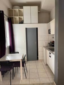eine kleine Küche mit einem Tisch und Stühlen in einem Zimmer in der Unterkunft Petit duplex gare Saint-Roch in Montpellier