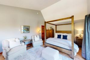a bedroom with a large bed and a chair at Lakeview Townhome Unit A5 in Avon