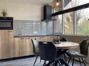 a kitchen with a wooden table and chairs and a counter at Achterhoekse vakantiewoning, infraroodsauna, geweldig uitzicht, goede bedden in Aalten