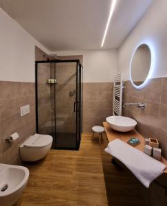 a bathroom with a shower and two sinks and a toilet at Agriturismo Donec in Villa dʼAllegno