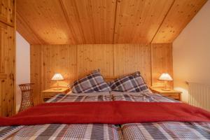 a bedroom with a bed with two lamps on tables at Ferienhaus Schmied in Egg