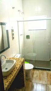 a bathroom with a sink and a toilet at Aconchegante Casa in São Lourenço