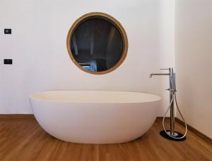 a white bath tub in a bathroom with a mirror at Agriturismo Donec in Villa dʼAllegno