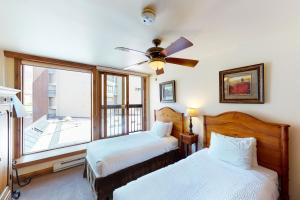 sypialnia z 2 łóżkami i wentylatorem sufitowym w obiekcie Vail Spa 301 w mieście Vail
