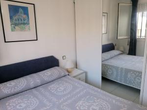 1 dormitorio con 2 camas y espejo en Arcos LEK, en Peñíscola