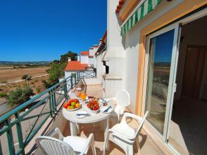 uma varanda com uma mesa e cadeiras com uma taça de fruta em Falesia Beach Apartment by Be Cherish em Albufeira