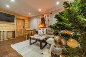 a living room with a christmas tree and a couch at Kozie Ranczo Domek Bacy in Bańska Niżna