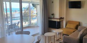 a living room with a couch and a table and a fireplace at Vasilis Studios in Kiveri