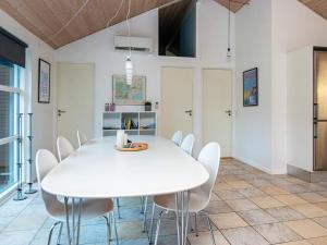 8 person holiday home in Ebeltoft في Øksenmølle: غرفة طعام بيضاء مع طاولة بيضاء وكراسي