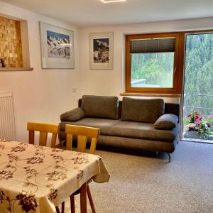 uma sala de estar com um sofá e uma mesa em Apart Garni Dorfblick em Kappl