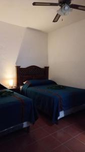 a bedroom with two beds and a ceiling fan at Hospedaje el Viajero Antigua ll in Antigua Guatemala