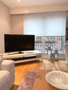 sala de estar con TV de pantalla plana grande en Merchant City Luxury 2 Bedroom Apartment with Secure Parking Available on Request, en Glasgow