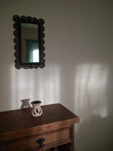 un miroir sur un mur au-dessus d'une table en bois dans l'établissement Eco Cabaña Rural, à La Consulta