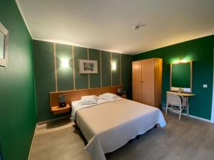 1 dormitorio con cama y pared verde en Hotel In Den Hoek, en Tielt