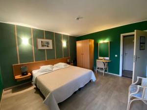 een slaapkamer met een bed en een groene muur bij Hotel In Den Hoek in Tielt