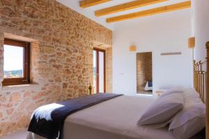 um quarto com uma cama numa parede de pedra em NEW LUXURY VILLA - Es Pujol de na Rita em La Mola