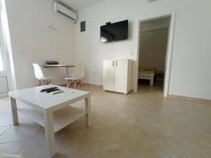 a living room with a white table and a tv at Dolce Far Niente in Herceg-Novi