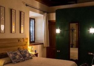 1 dormitorio con cama y pared verde en Molino La Nava, en Montoro