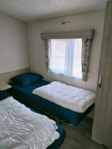 Een bed of bedden in een kamer bij BJ Chalets - De Rug 1 - Vakantiepark Lauwersoog - LUXE, kindvriendelijke chalet MET vaatwasser! Vroege incheck!