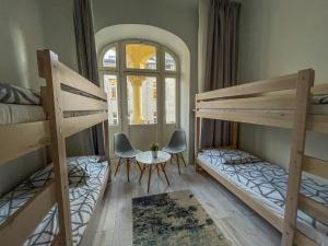 a room with two bunk beds and a table and chairs at Moon Hostel Warszawa in Warsaw