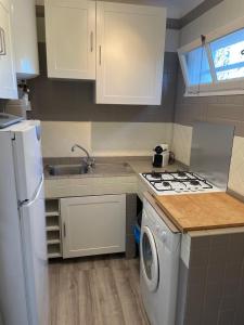 een keuken met een fornuis en een wasmachine bij Appartement Bord de Mer La Faviere in Bormes-les-Mimosas