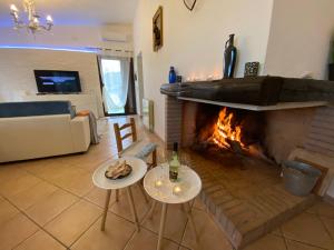 - un salon avec une cheminée, deux tables et un canapé dans l'établissement Villa Bianca, à Tertenìa