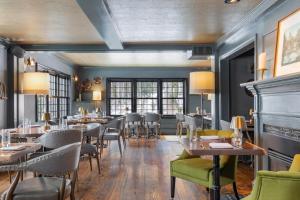 a dining room with tables and chairs and windows at The Hermitage Inn Vermont in West Dover