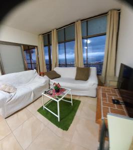 uma sala de estar com um sofá branco e uma mesa em Amazing Panorama Bay view 3 room flat em Haifa