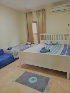um quarto com 2 camas e um sofá azul em Amazing Panorama Bay view 3 room flat em Haifa