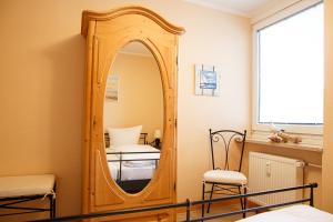 einen Spiegel in der Ecke eines Zimmers mit einem Bett in der Unterkunft Haus Uthlande Uthlande Whg 4 in Wyk auf Föhr