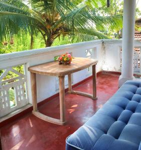 a wooden table on a porch with a palm tree at location weligama in Weligama