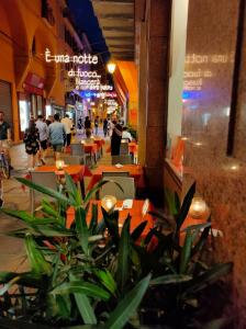 a street with tables and people walking in a mall at Hotel Roma in Bologna