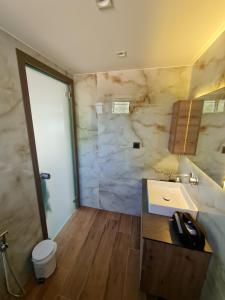 a bathroom with a sink and a stone wall at Amaryllis Luxury Living in Nea Vrasna