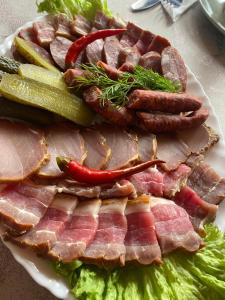 a plate of meat and vegetables on a table at Verkhovinsky Dvor in Kostryna +21 photos