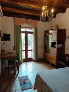 1 dormitorio con cama, escritorio y ventana en Il Cortile del Castello, en Capena