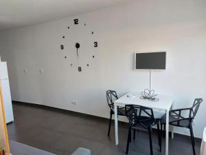 ein Esszimmer mit einem Tisch und einer Uhr an der Wand in der Unterkunft Apartamento Turismo Badajoz in Badajoz