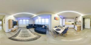 a living room with a blue couch and a table at Gamma Apartmanok és Jakuzzi in Miskolctapolca