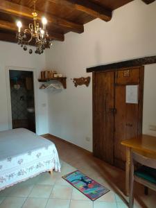 um quarto com uma cama, uma mesa e um lustre em Il Cortile del Castello em Capena