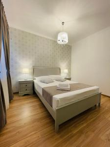 - une chambre avec un grand lit et un lustre dans l'établissement Royal Moonlight Apartment, à Mamaia