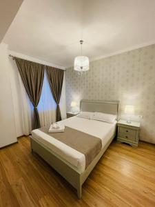 een slaapkamer met een groot bed en een kroonluchter bij Royal Moonlight Apartment in Mamaia