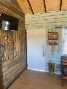 a room with a white door and a flat screen tv at Casita Pueblo in La Coronilla