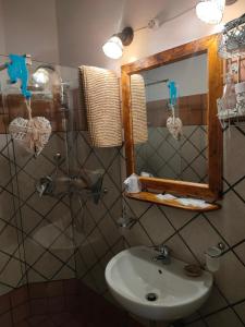 bagno con lavandino e specchio di Il Cortile del Castello a Capena